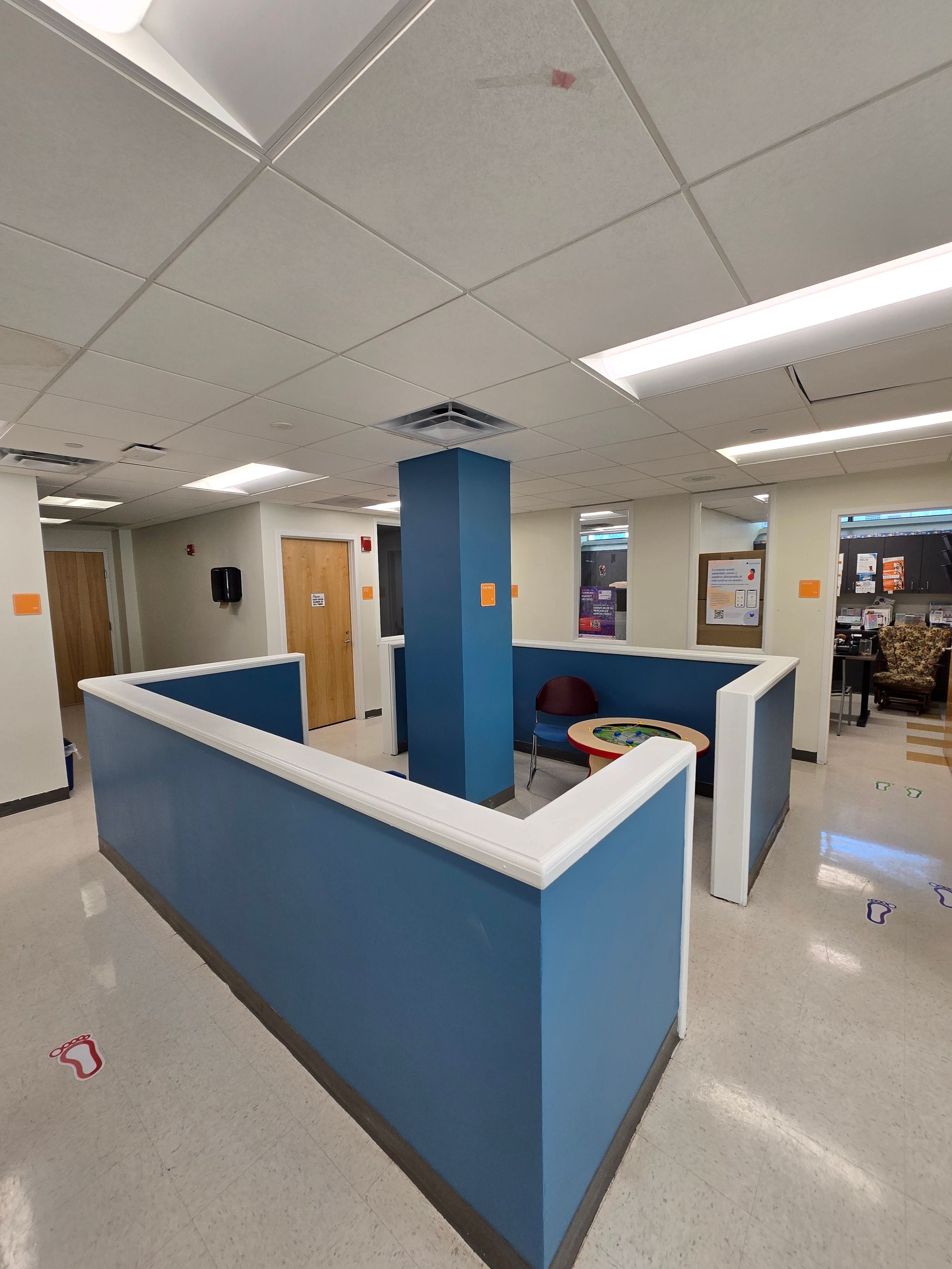 Blue and white seating area in a room with beige walls, a central blue pillar, and a round table.