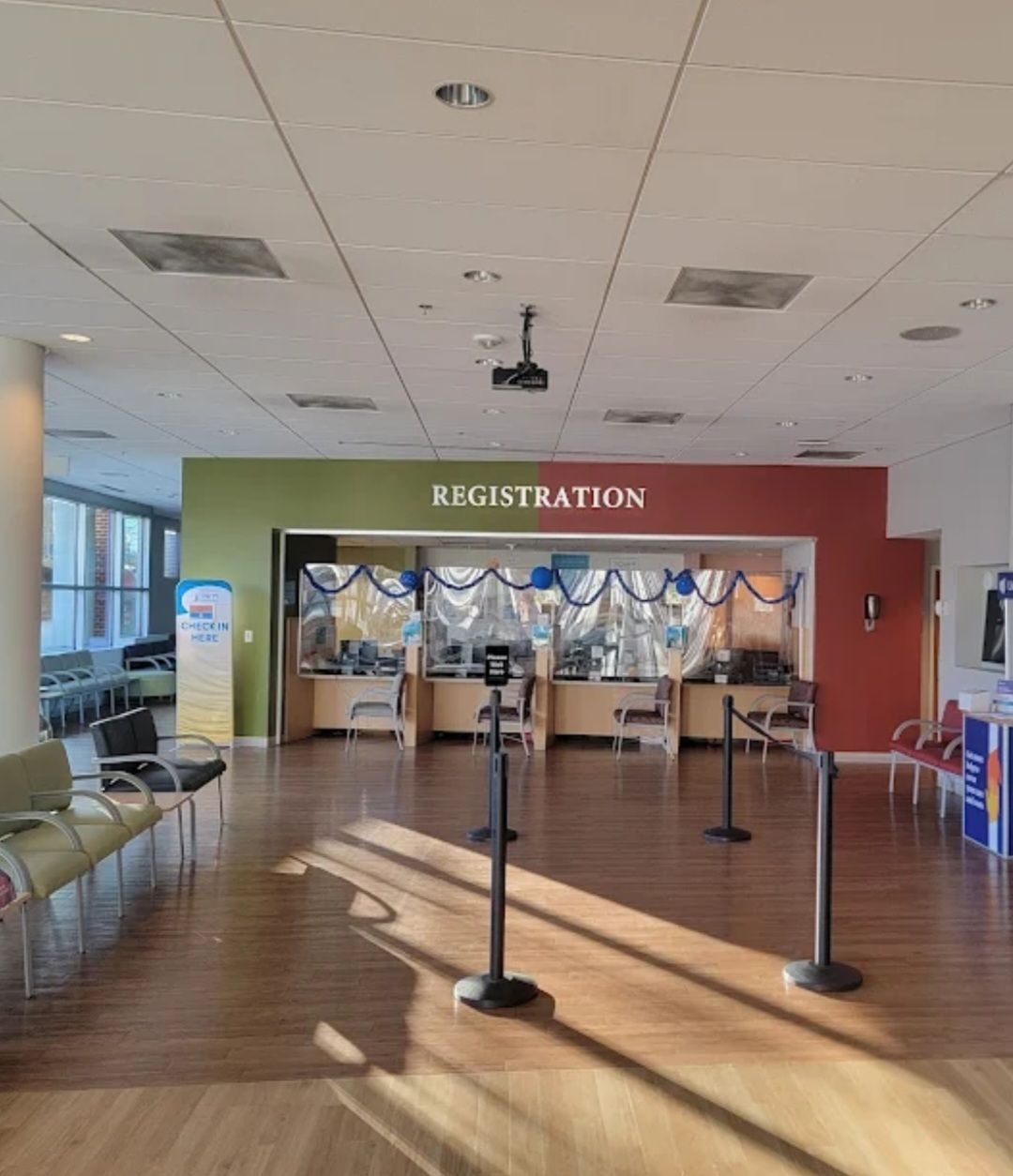 A hospital registration area with a counter, seating, and a projector.