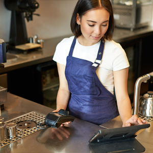 Female server using a tablet EPOS in a coffee shop