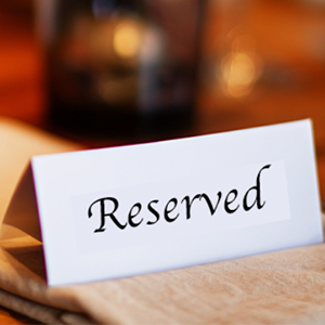 A folded 'reserved' card on a restaurant table