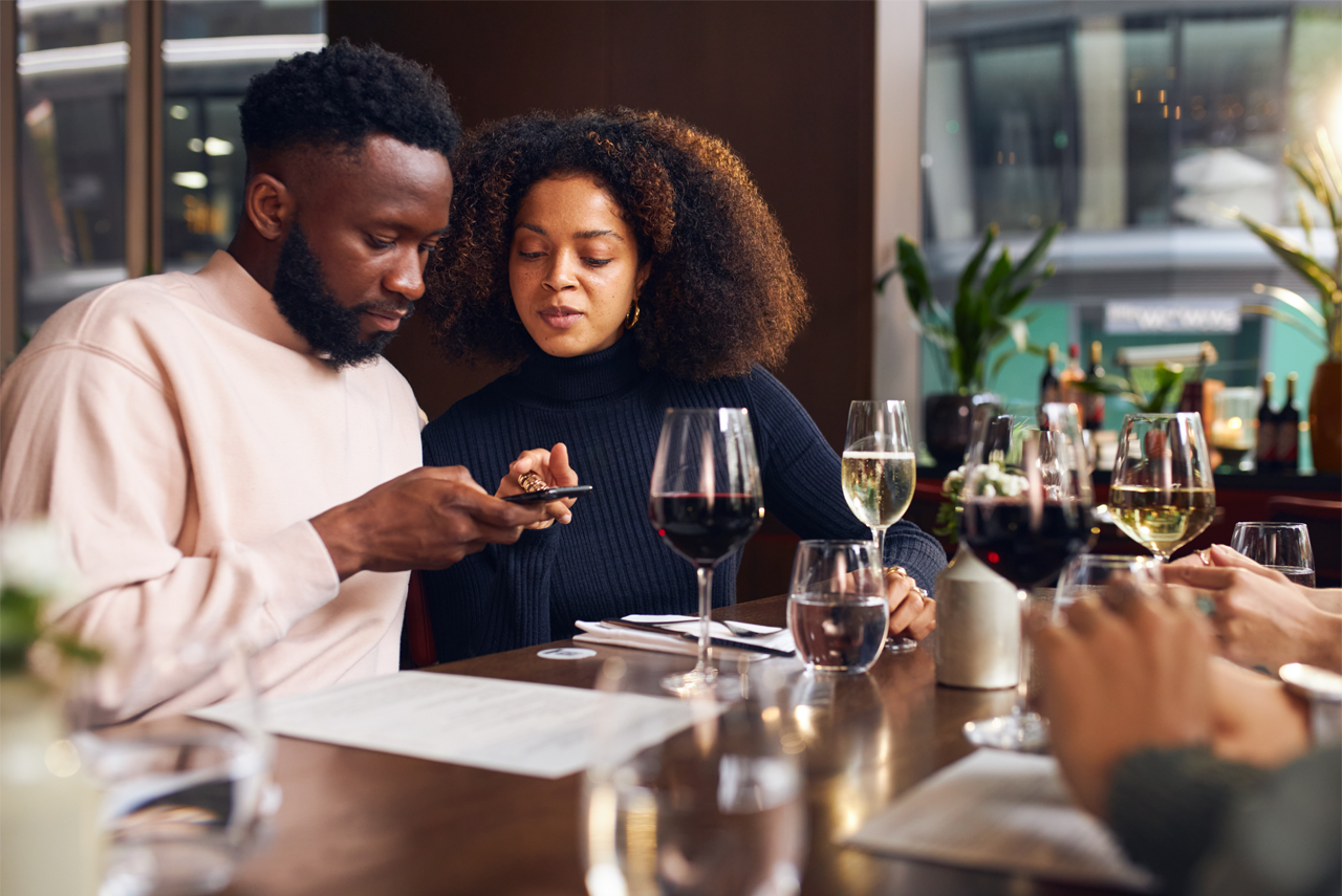 Man & woman using QR code in a restaurant