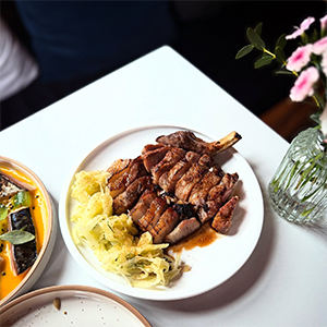 A plate of sliced pork and shredded vegetables on a restaurant table