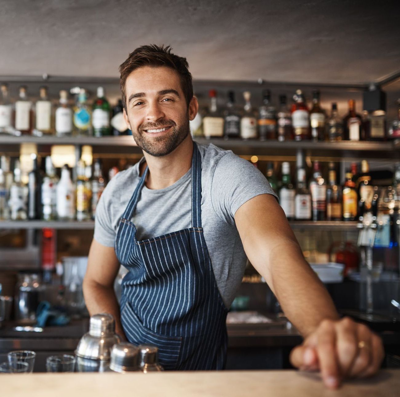 Man smiling behind a bar