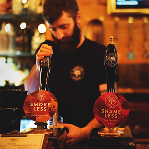A bartender pulls beer from RedWillow Brewery beer pumps