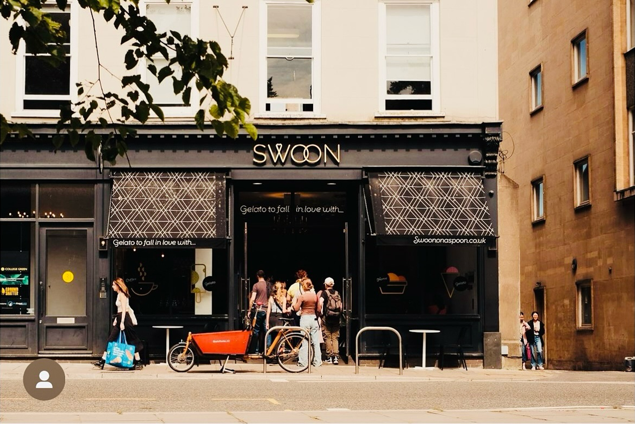 A street-level view of a dark-framed storefront named 