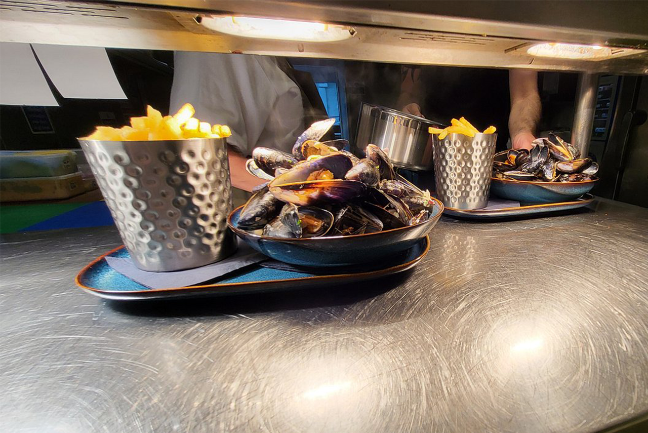 Four people toasting drinks: beer and cocktails