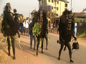 A group of people dressed in black are walking down a street