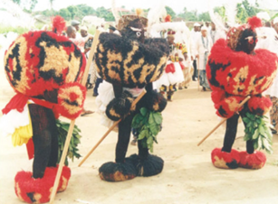 A group of people are standing in a line wearing costumes and holding sticks