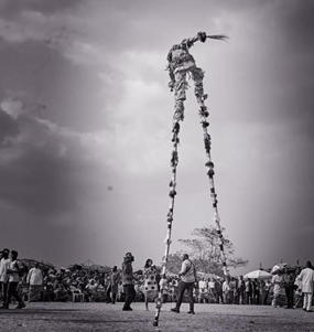 A black and white photo of a man on stilts