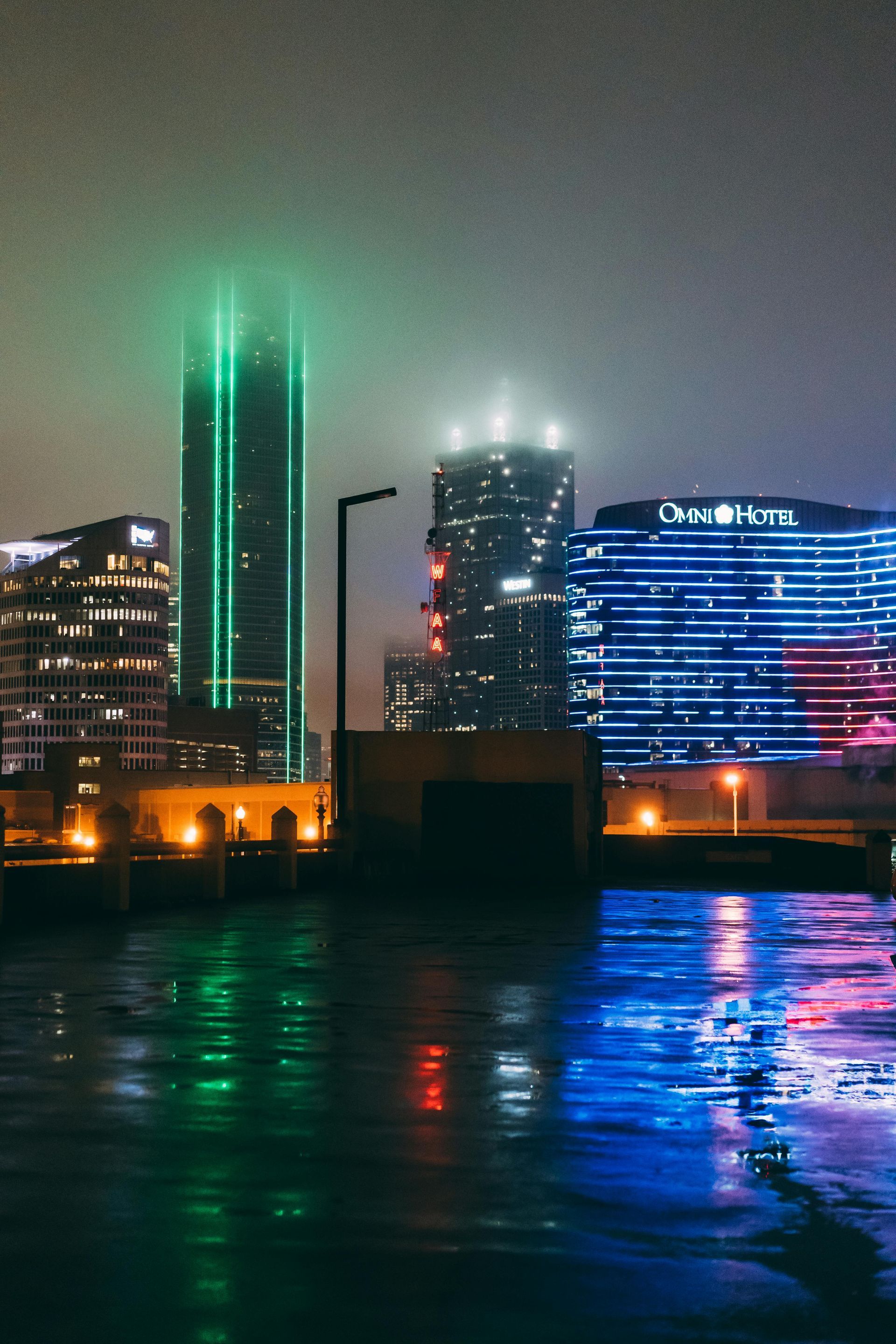 A city skyline at night with the drax hotel in the foreground