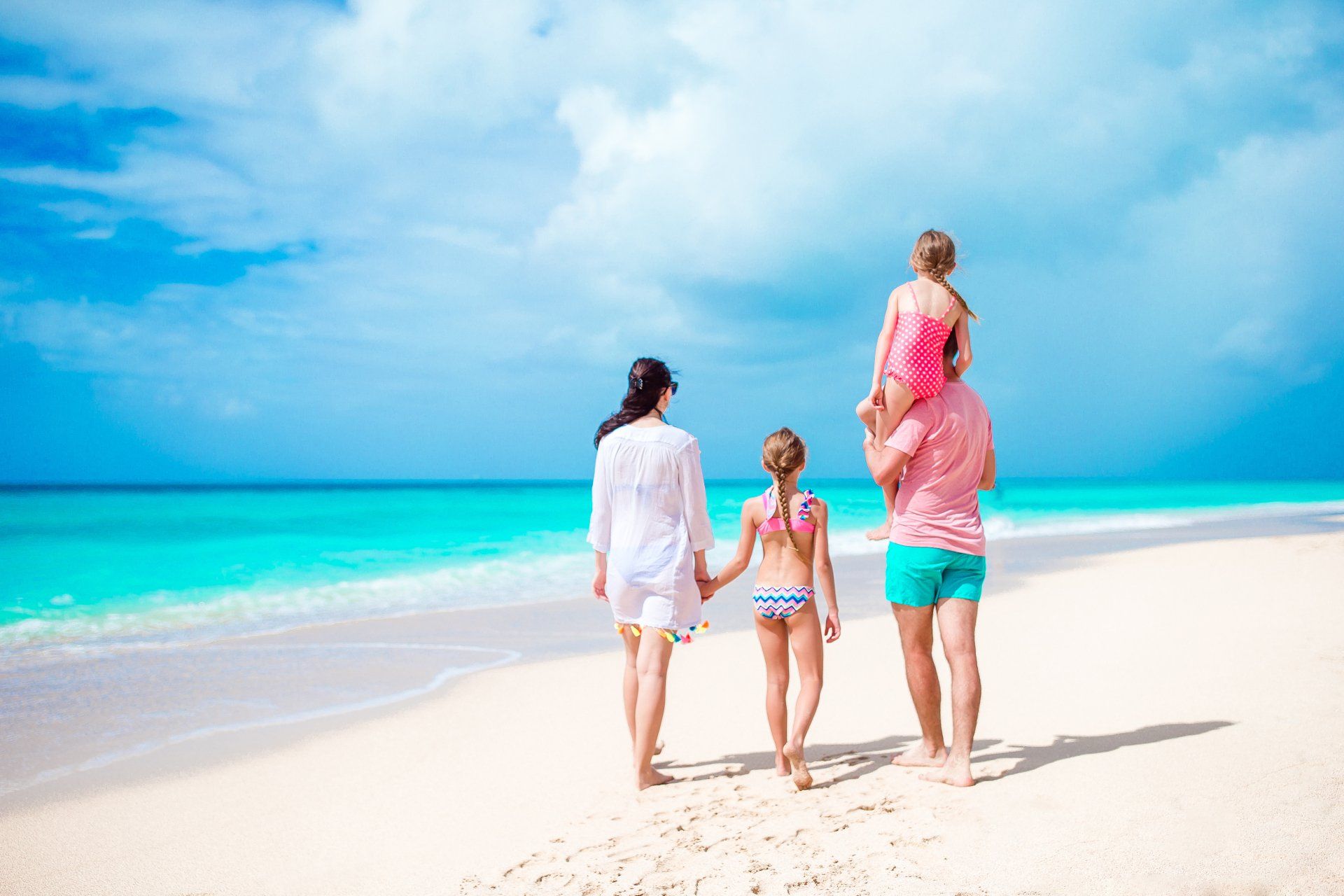 Familia caminando por la playa en San Andrés, imagen asociada a hoteles en San Andrés para familias.