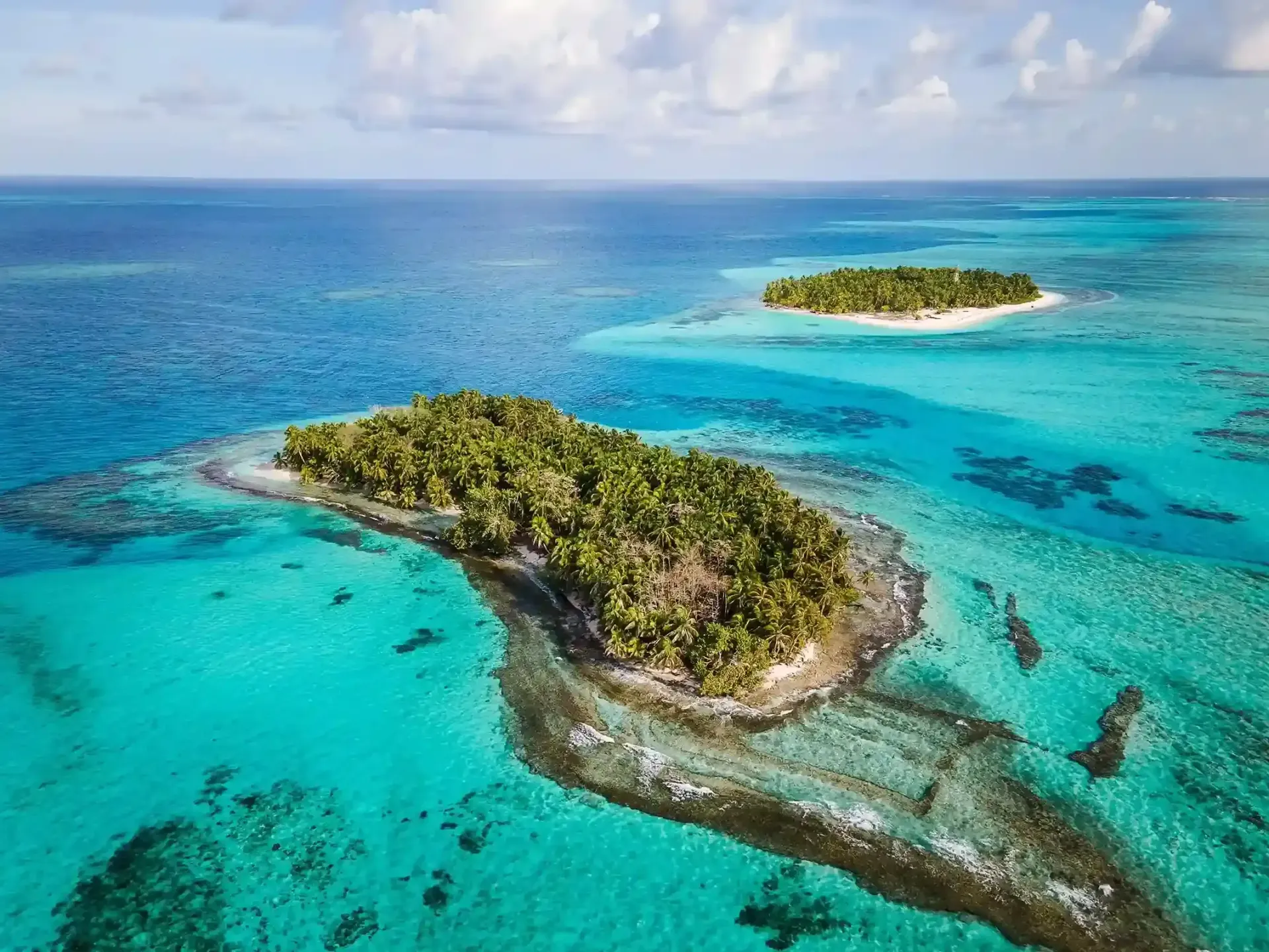 Vista aérea de un islote rodeado de aguas turquesas, un ejemplo del encanto natural del Caribe colombiano.