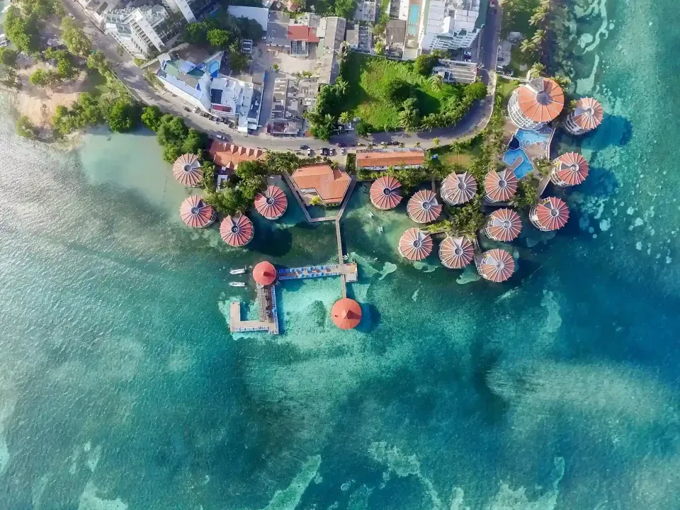 Vista aérea de la zona hotelera de San Andrés, cerca del Hotel Aqualina Inn, con cabañas sobre el mar Caribe y fácil acceso a playas como Spratt Bight.