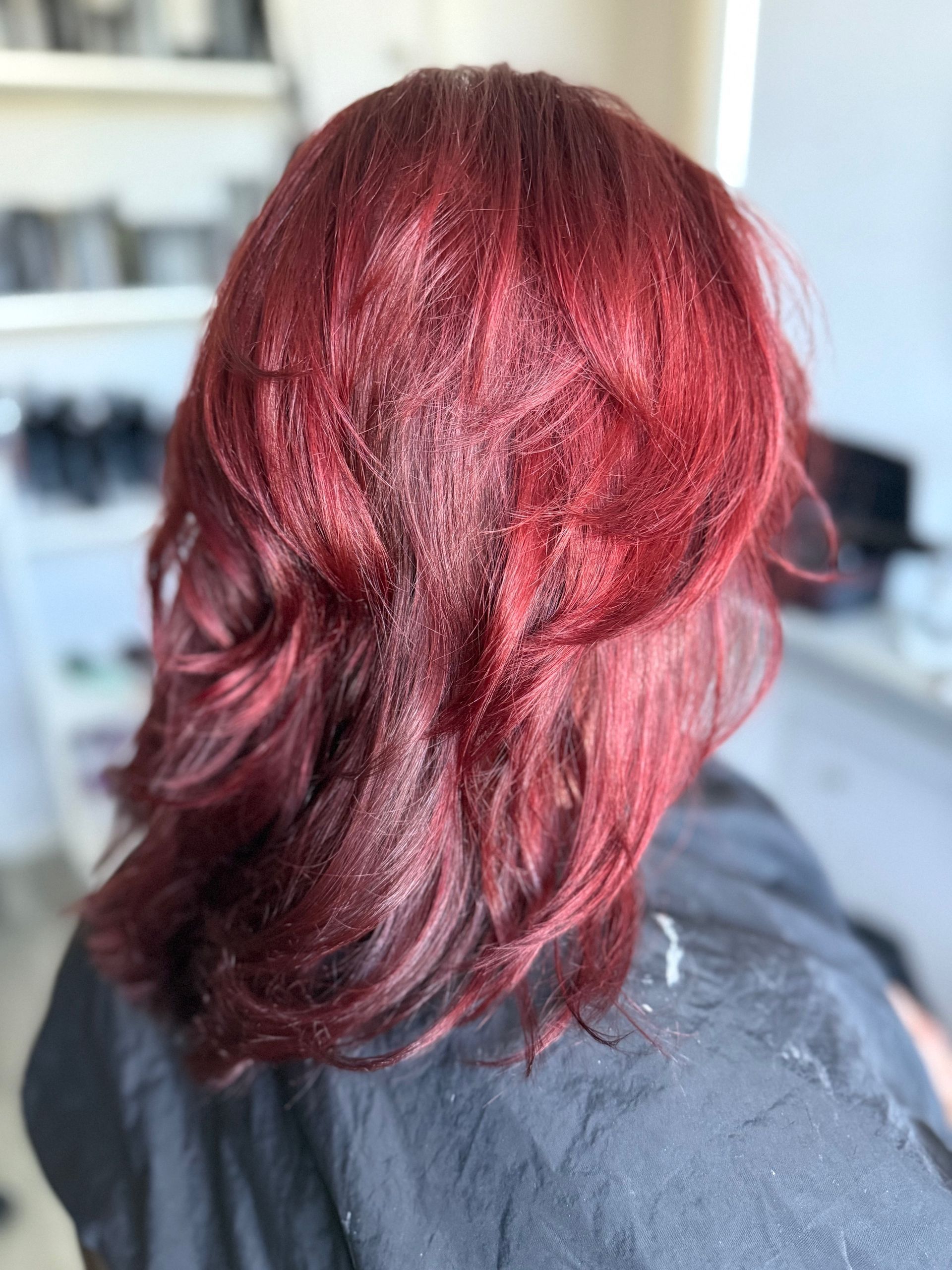 Gelaagde snit in rood haar, van de achterkant gezien.