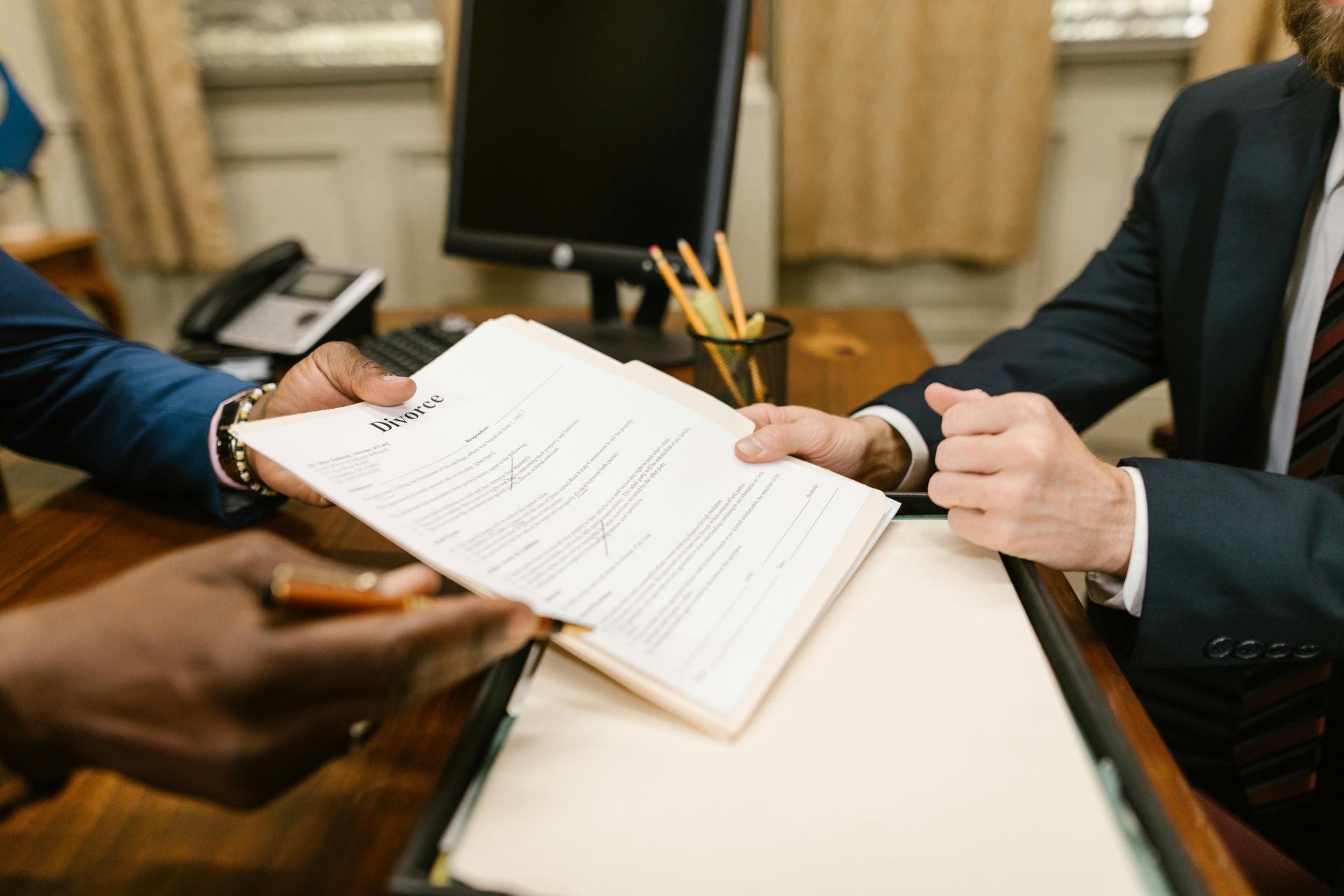 Two people in business suits reviewing a document across a table in a meeting room