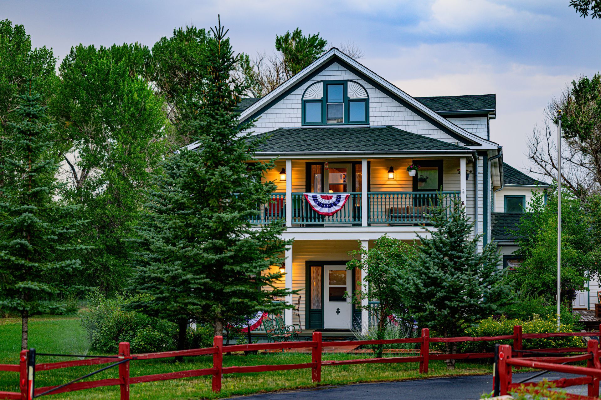 A snowy house with a red fence in front of it