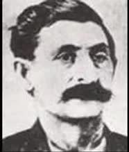 A black and white photo of a man with a mustache.