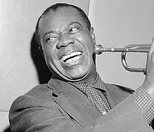 A black and white photo of a man playing a trumpet and smiling.