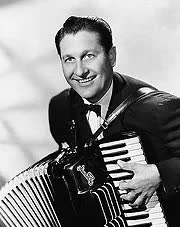 A man in a tuxedo is playing an accordion in a black and white photo.