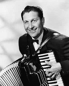 A man in a suit and bow tie is playing an accordion.