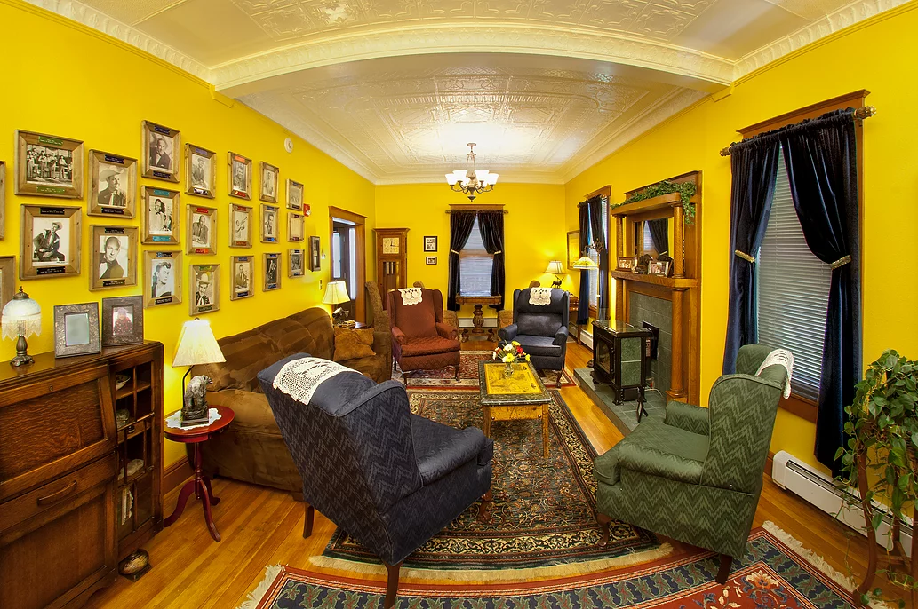 A living room with yellow walls and lots of furniture
