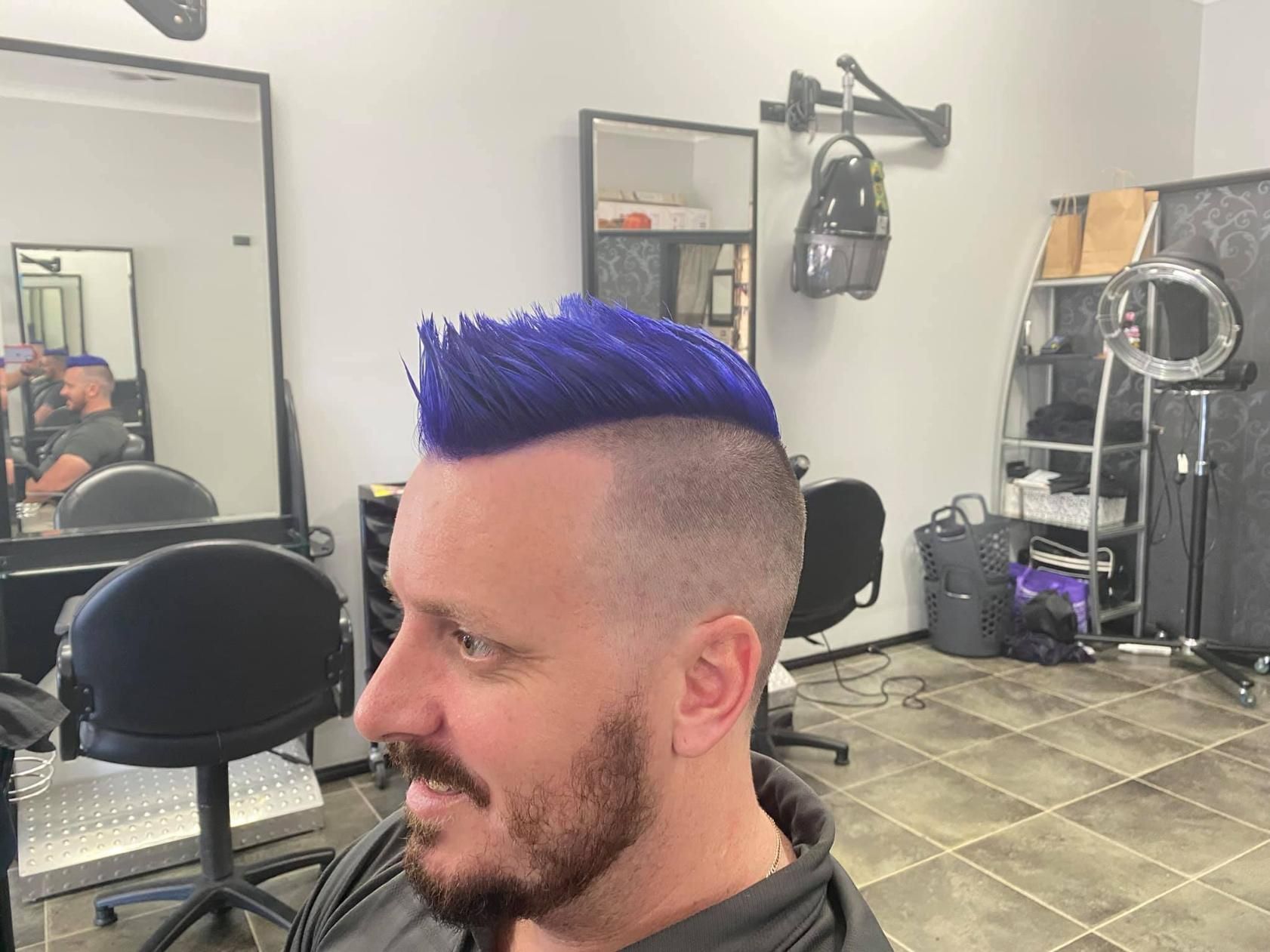A Man With Blue Hair Is Getting His Hair Cut In A Salon — Klic's Hair Design In Earlville, QLD