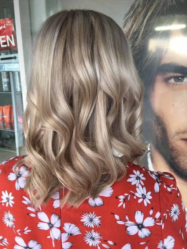 A Woman With Blonde Hair Is Wearing A Red Floral Shirt — Klic's Hair Design In Earlville, QLD