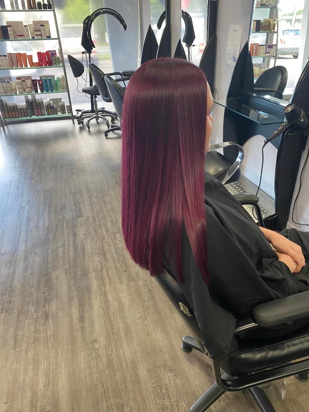 A Woman With Purple Hair Is Sitting In A Chair In A Salon — Klic's Hair Design In Earlville, QLD