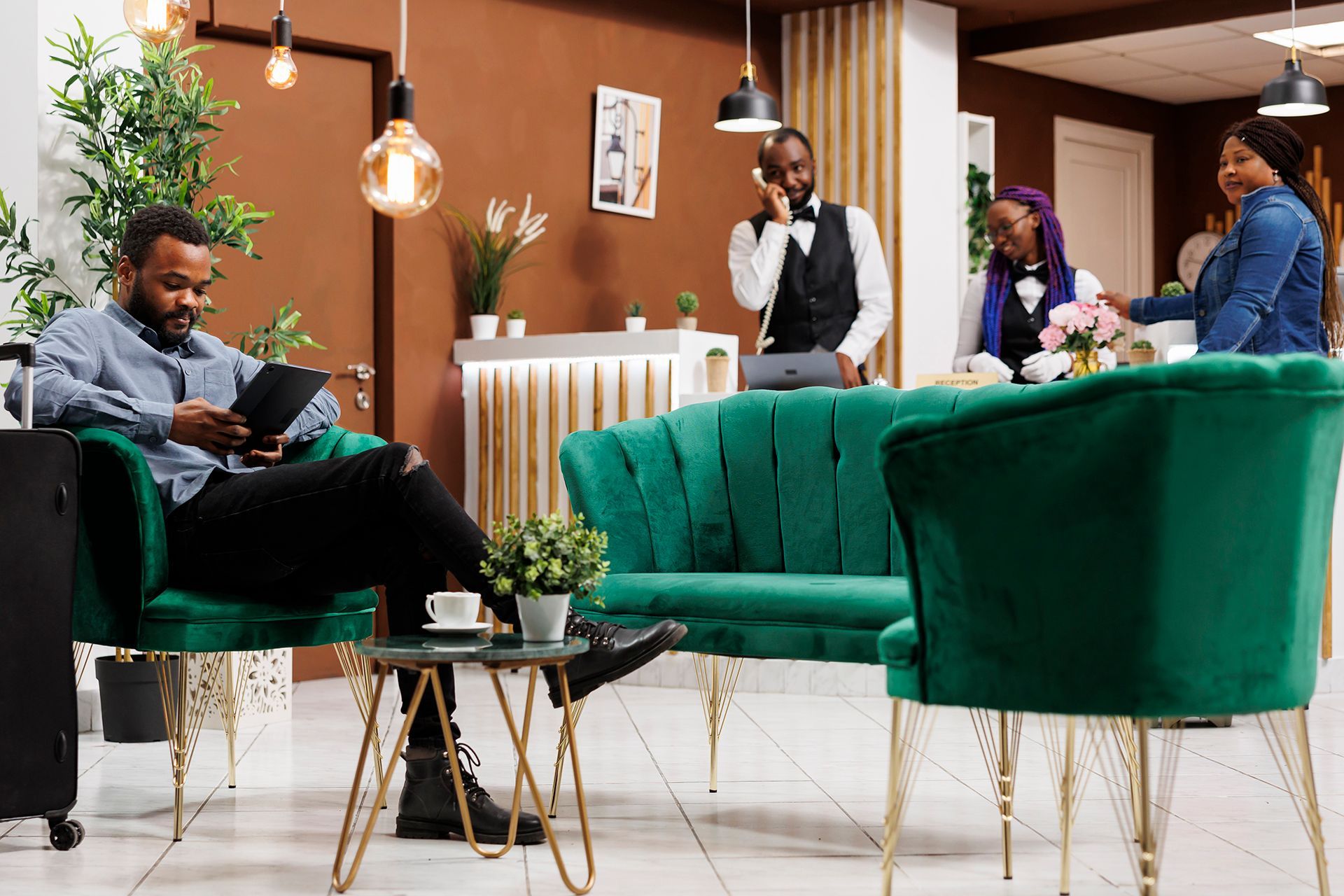 A man is sitting in a green chair reading a book
