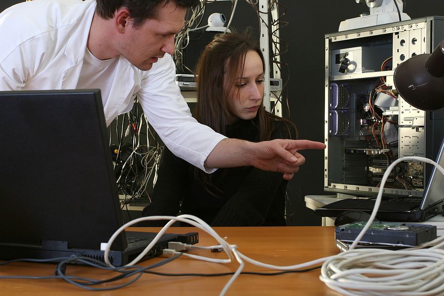 A man and a woman are working on a computer