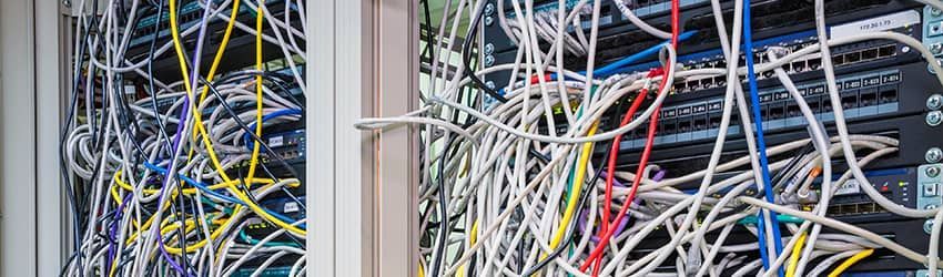 Server room with tangled network cables in multiple colors.