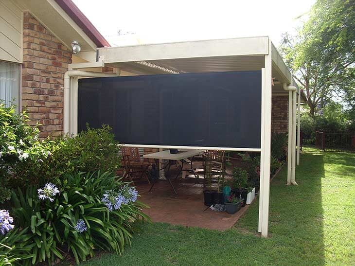 Patio With Retractable Black Screen.  Brick Building, Green Lawn ā Toowoomba Shade & Canvas in Harristown, QLD