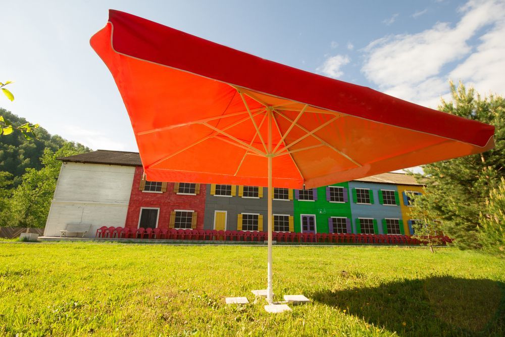 Red Square Umbrella Over a Colorful Building — Toowoomba Shade & Canvas in Harristown, QLD