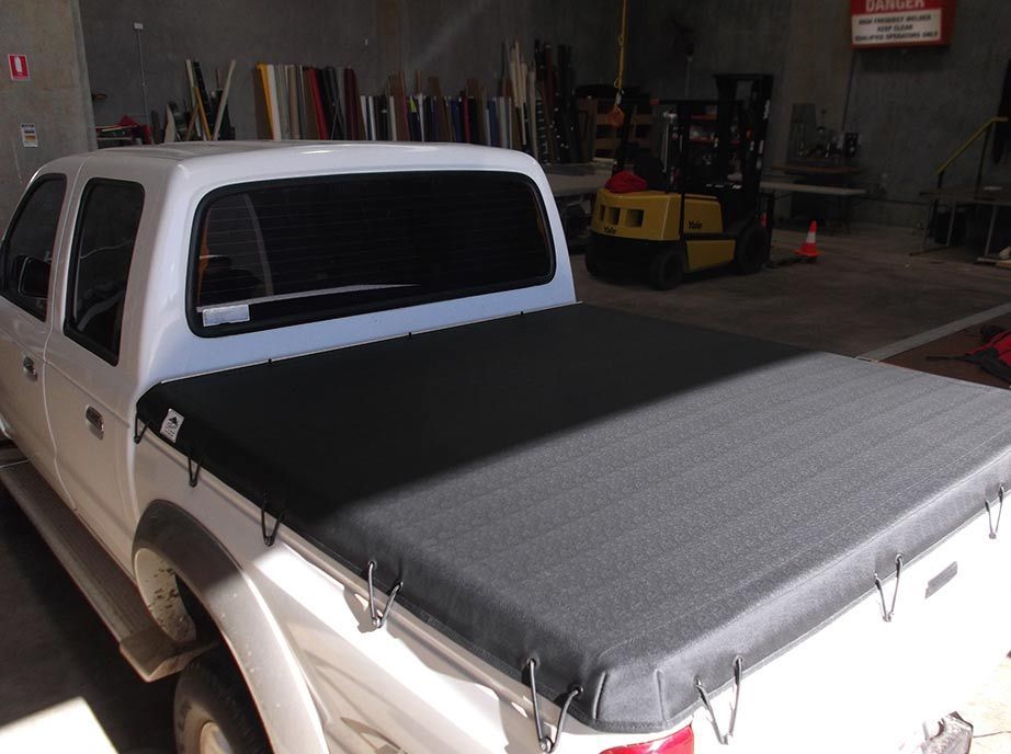 White Truck With Black Tonneau Cover in a Workshop — Toowoomba Shade & Canvas in Gatton, QLD