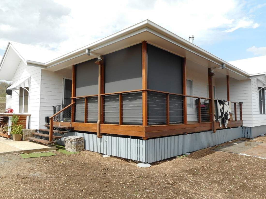 White House With Brown Deck, Dark Shades, and Wooden Railing — Toowoomba Shade & Canvas in Harristown, QLD