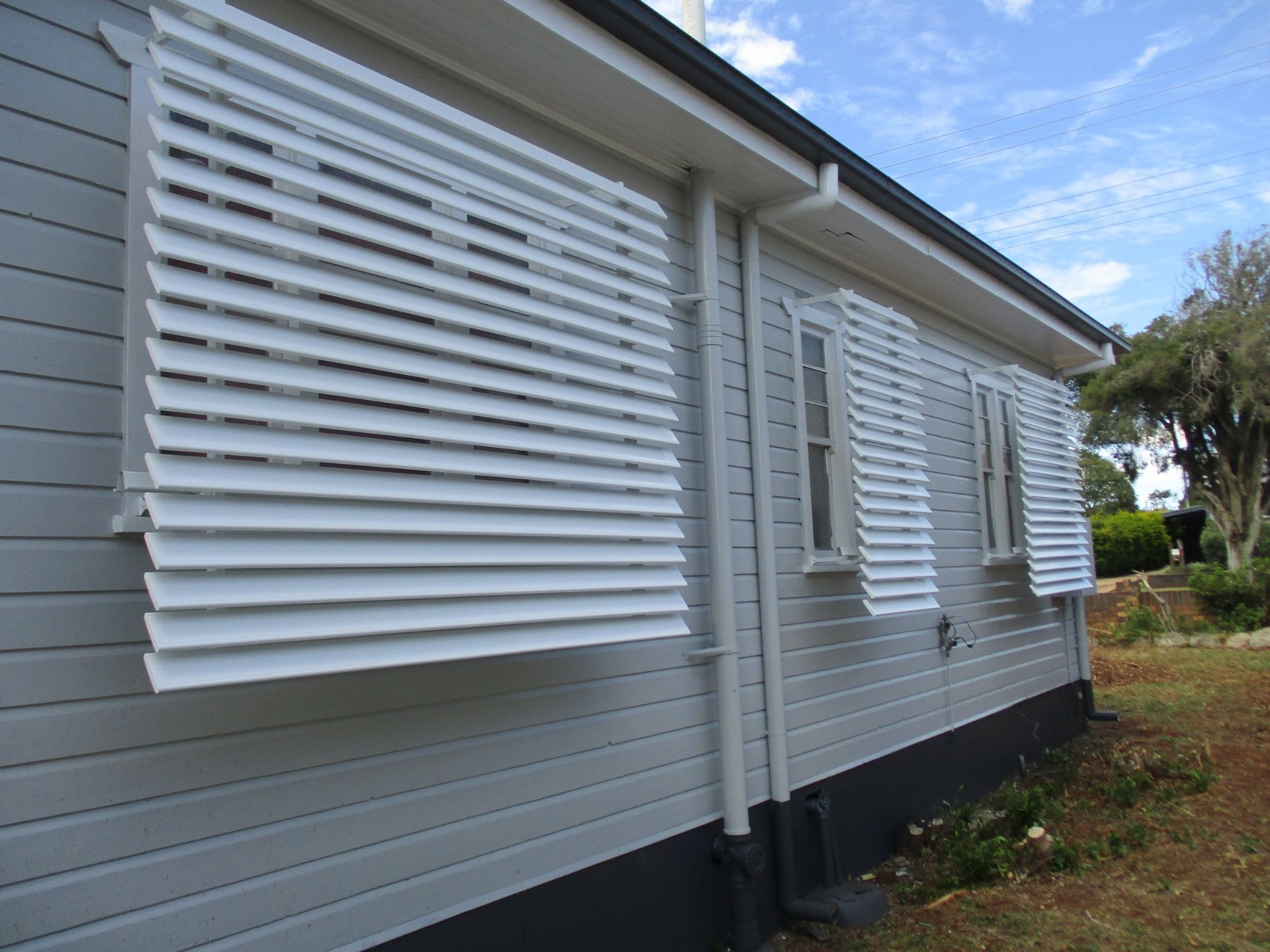 Gray House With White Louvered Shutters — Toowoomba Shade & Canvas in Warwick, QLD