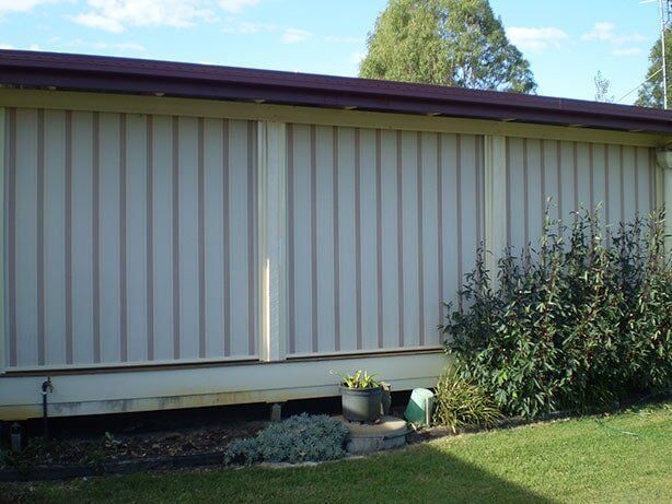 Beige Corrugated Siding on a Building With a Brown Roof — Toowoomba Shade & Canvas in Harristown, QLD