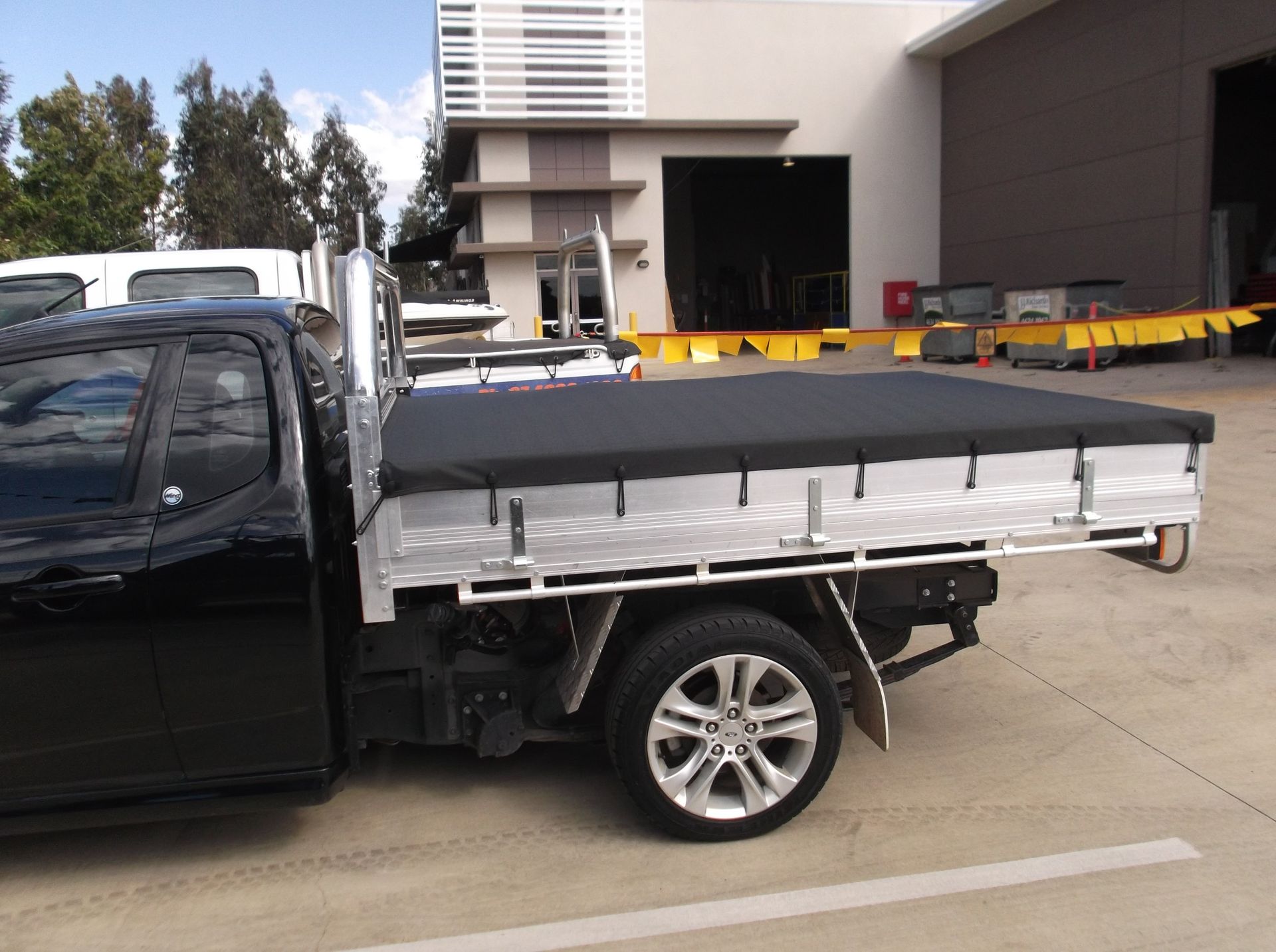 Black Pickup Truck With an Aluminum Flatbed and Black Tarp — Toowoomba Shade & Canvas in Harristown, QLD