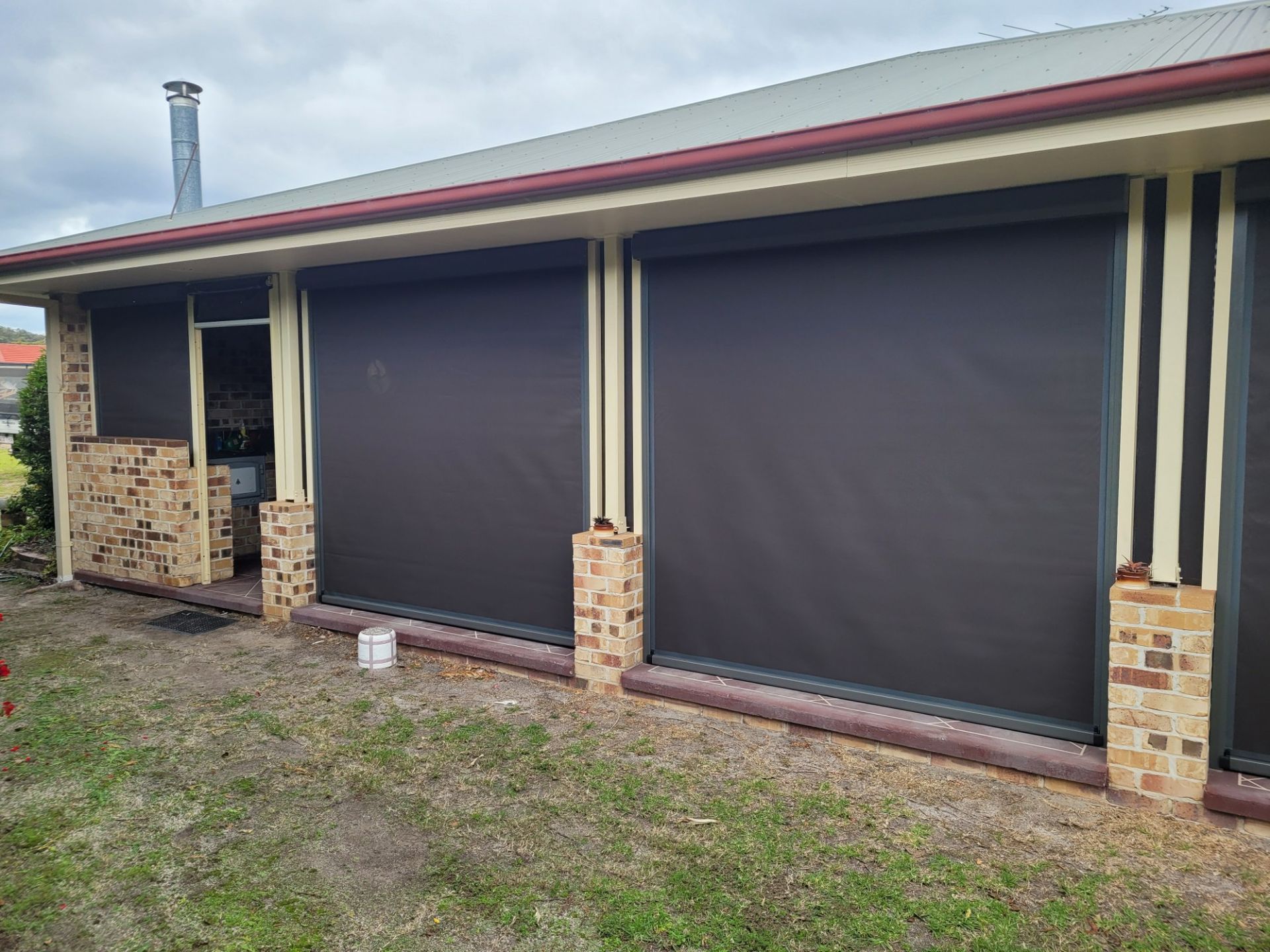 Exterior View of a House With Dark Roller Shades — Toowoomba Shade & Canvas in Harristown, QLD