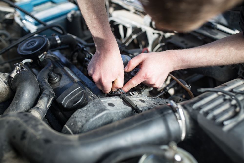 A Man Is Doing Mechanical Work On The Engine Of A Car — Dunhams Auto Repairs In Woonona, NSW