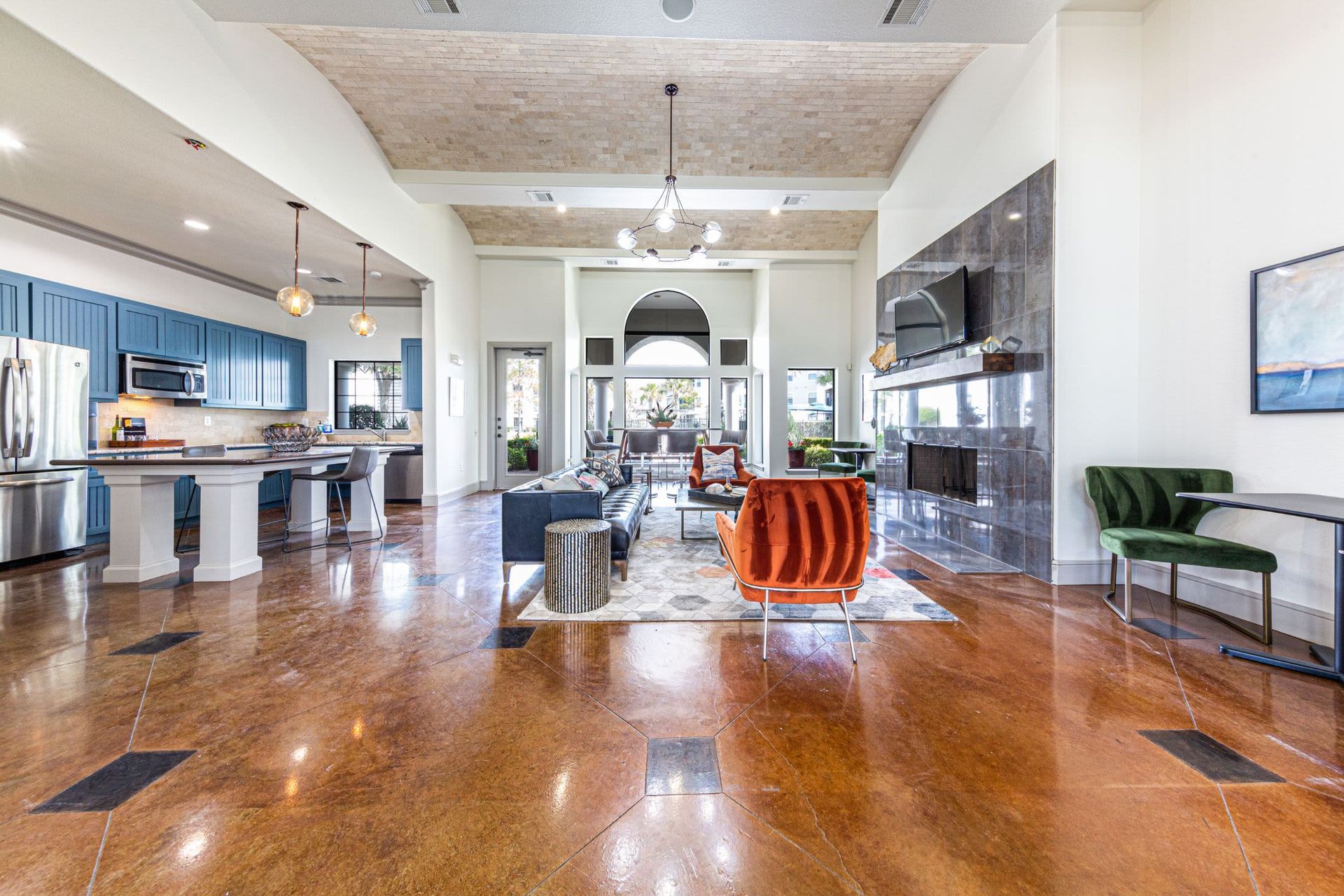 A large living room filled with furniture and a kitchen at Marquis Grand Lakes in Richmond, TX.