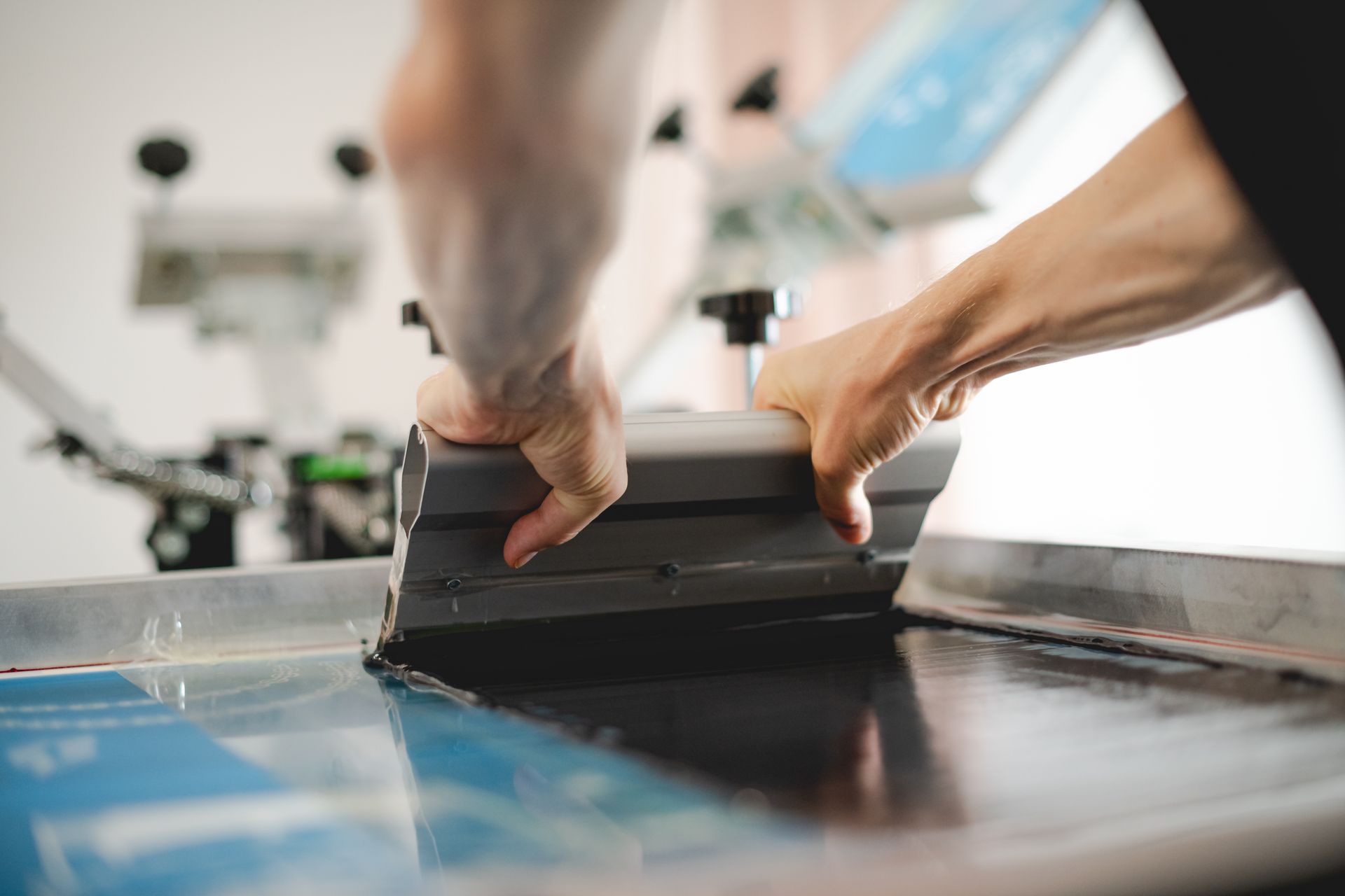 Person using a heat press to apply a design to a black t-shirt.