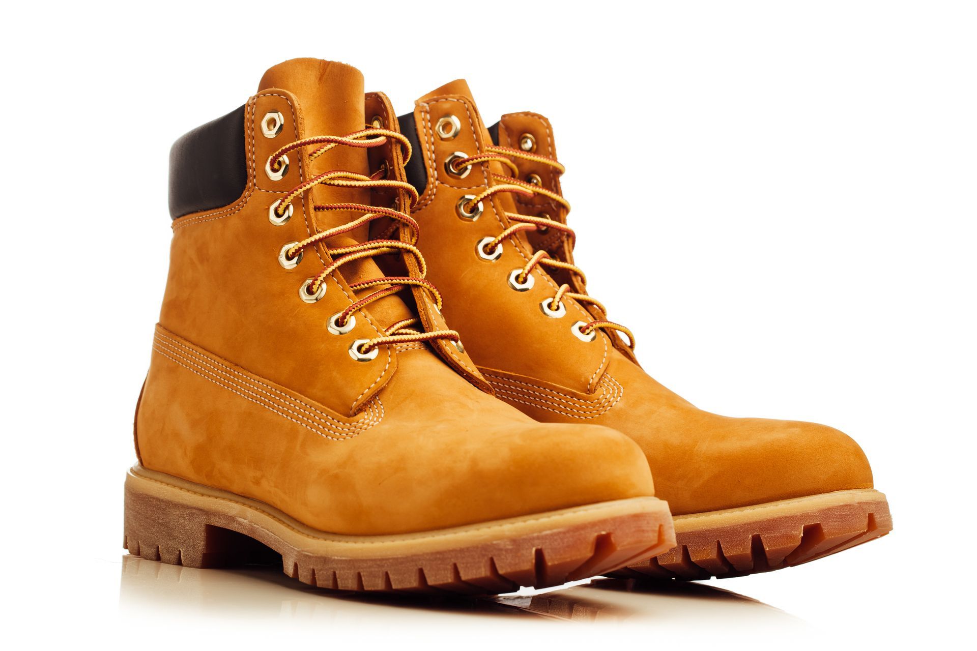 Pair of tan Timberland work boots with brown rubber soles and gold eyelets.