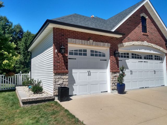 Brickhouse with garage doors - Eureka, MO | Perfect Pitch Roofing & Exteriors Inc