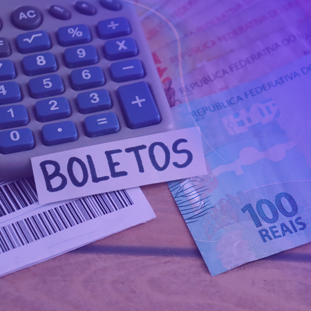 Uma calculadora ao lado de um adesivo que diz boletos