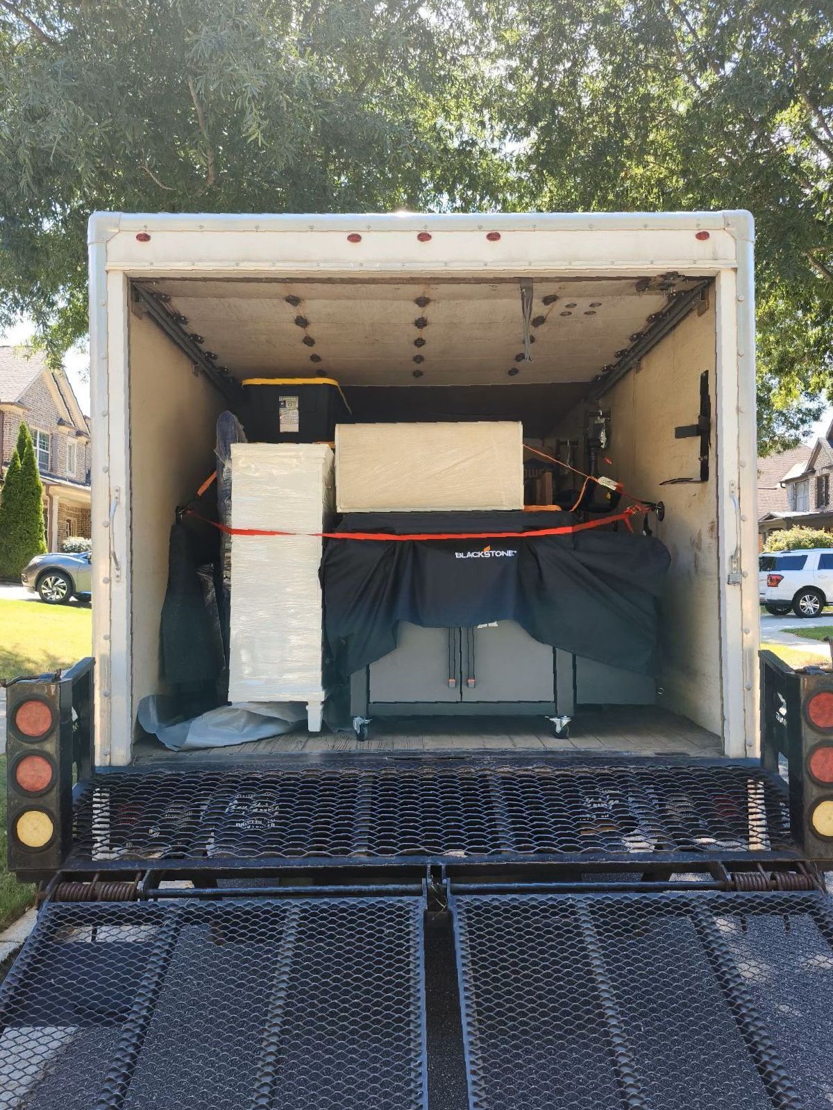 The back of a moving truck is filled with boxes and appliances