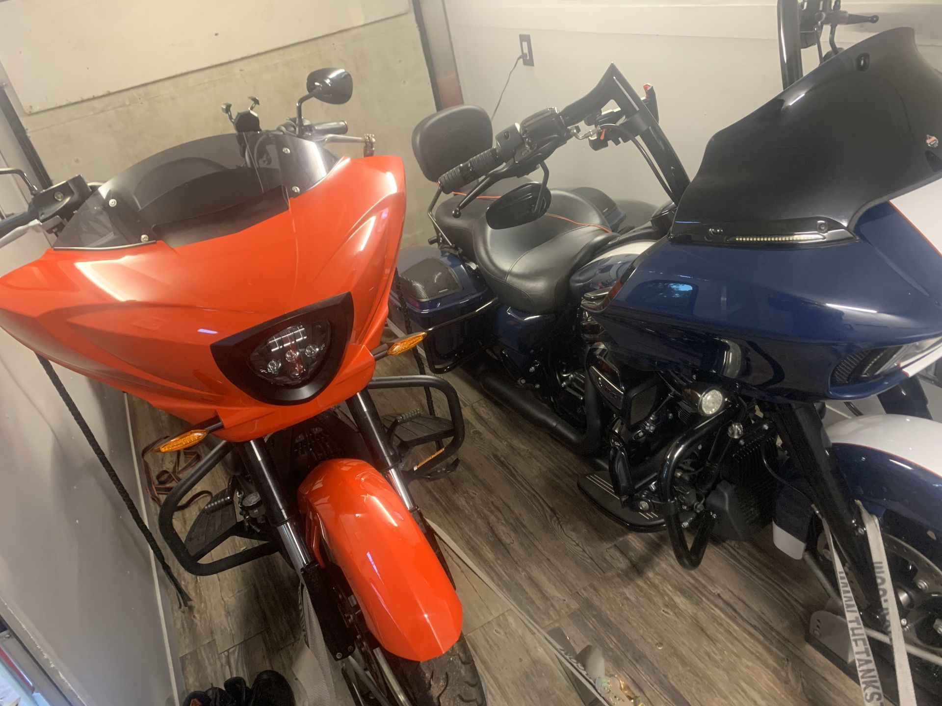 Two motorcycles are parked next to each other in a garage.