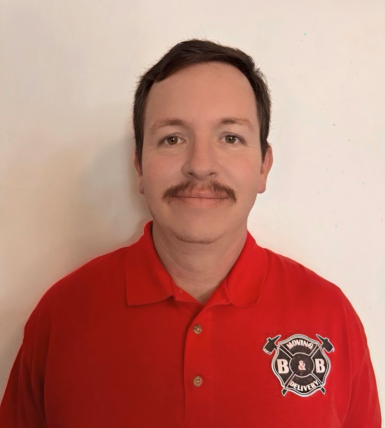 A man wearing a red shirt with the letter b on it