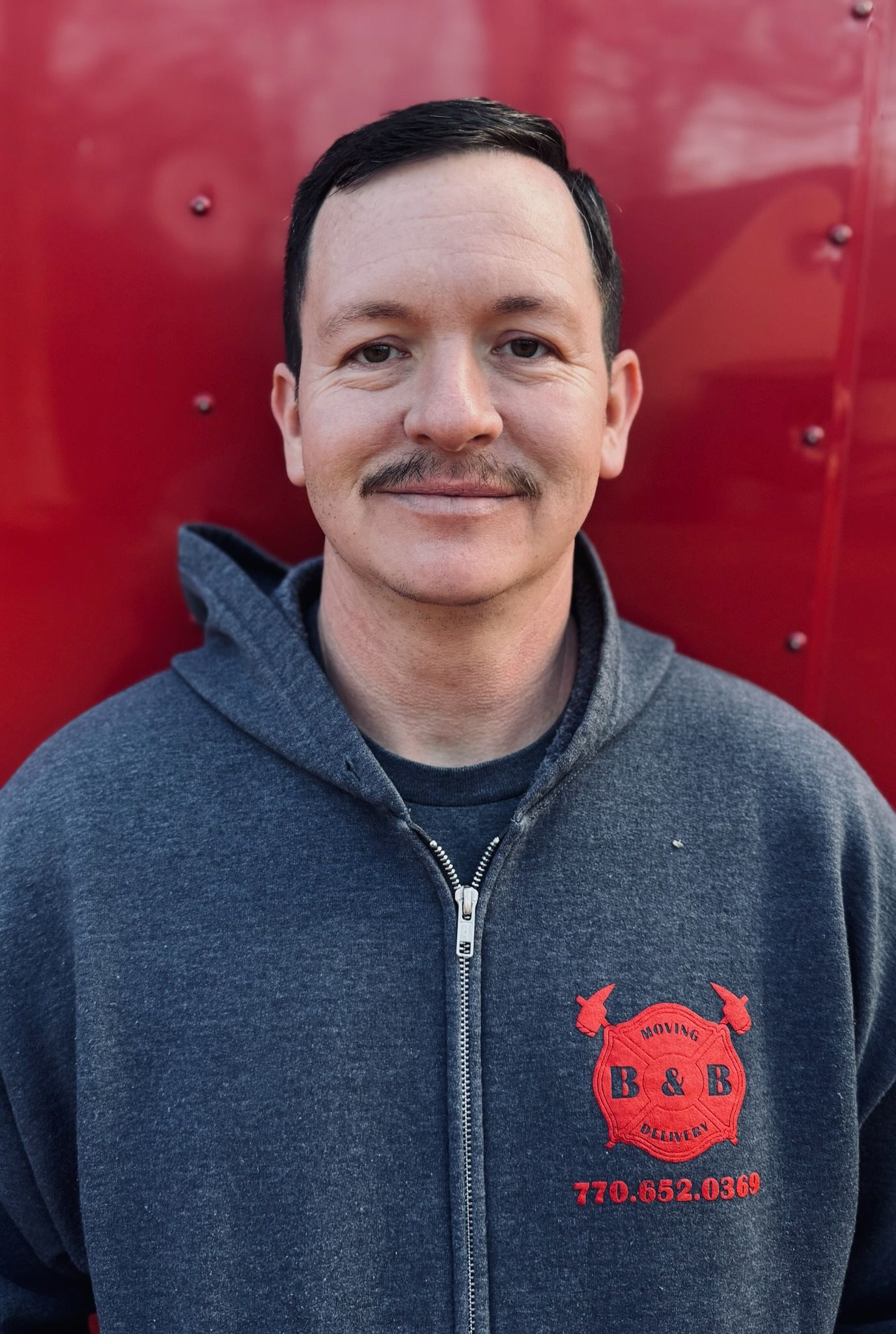 A man wearing a red shirt with the letter b on it