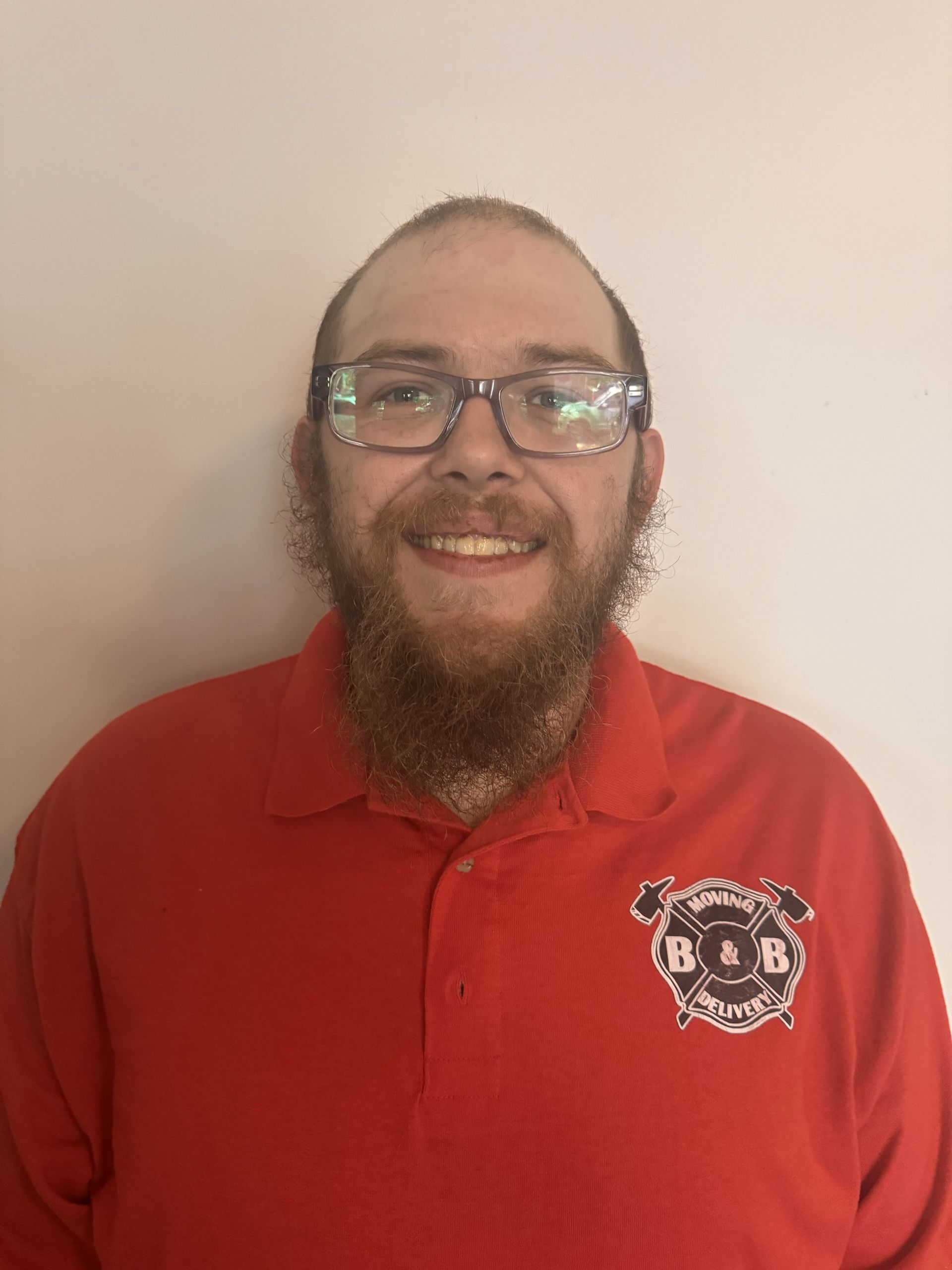 A man with a beard wearing glasses and a red shirt